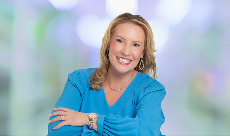 Kimberly Young smiling in bright blue blouse