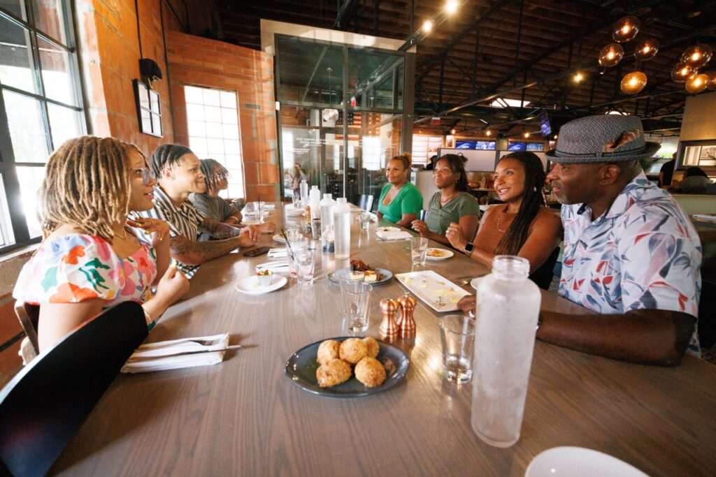 Danan Hughes and family sitting around a table at Third Street Social. 