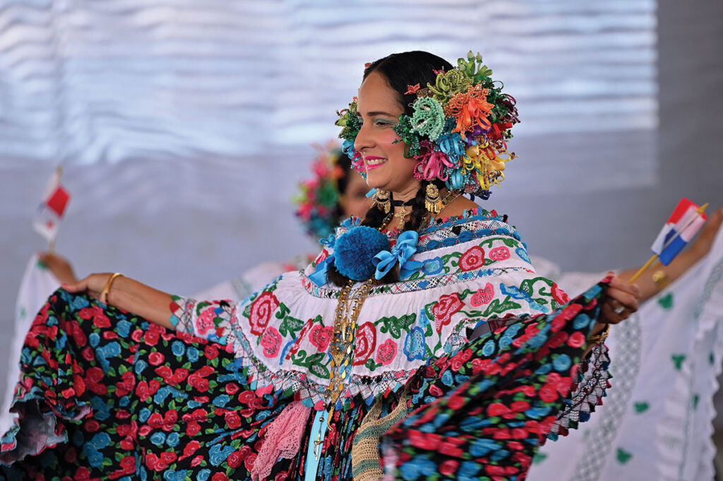 A woman in a colorful dress dances at the Ethnic Enrichment Festival.