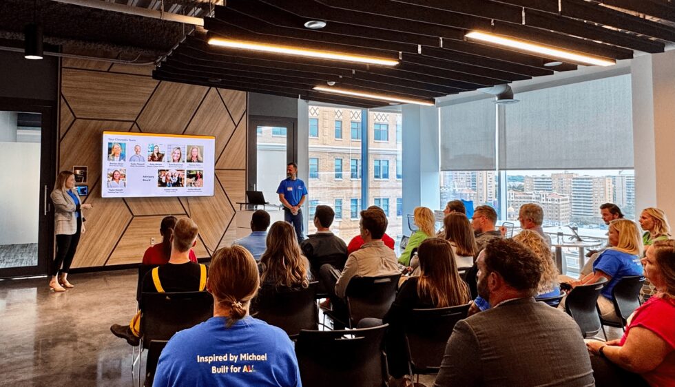 Two people standing in front of a classroom full of adults