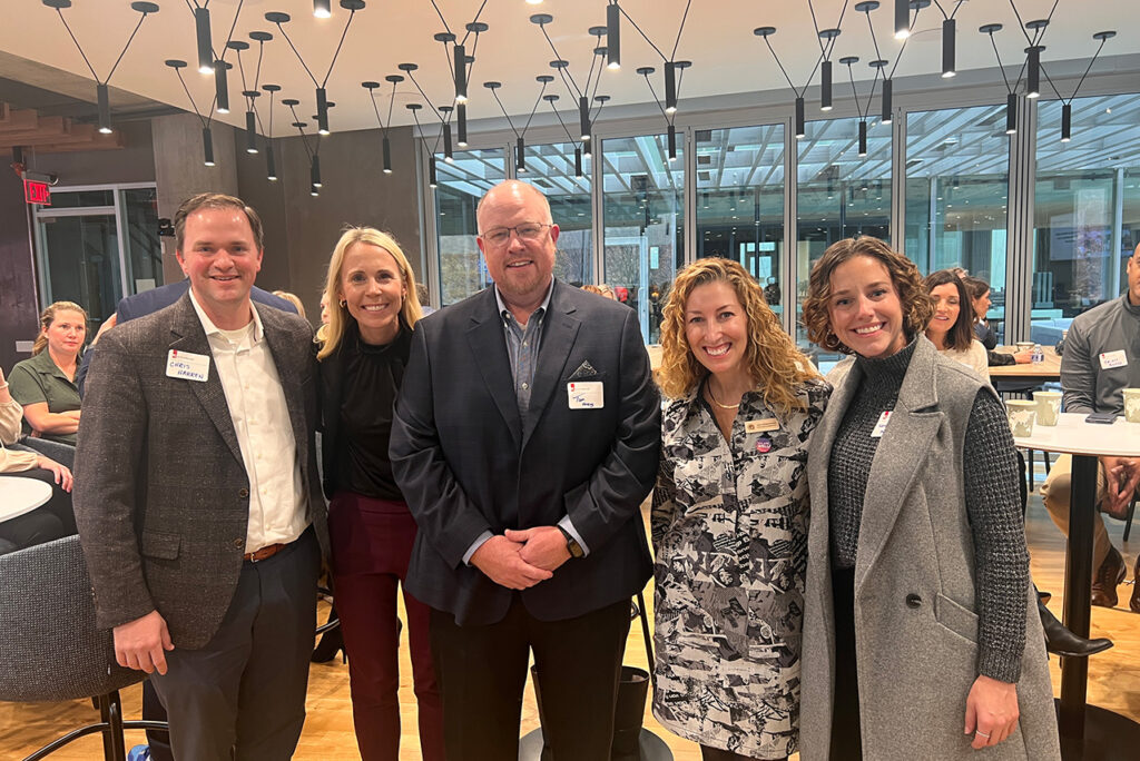 People smiling together at a KC Global Design Innovation Shop Talk hosted at JE Dunn