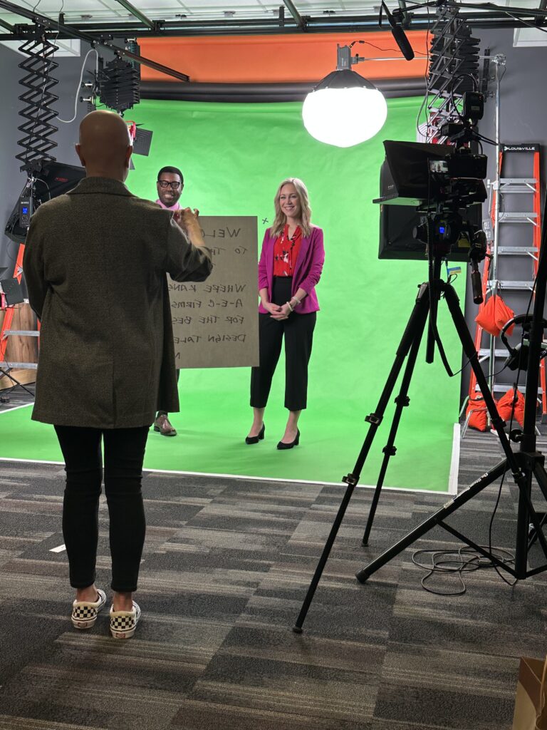 Three people around a green screen recording the KC Global Design Draft video