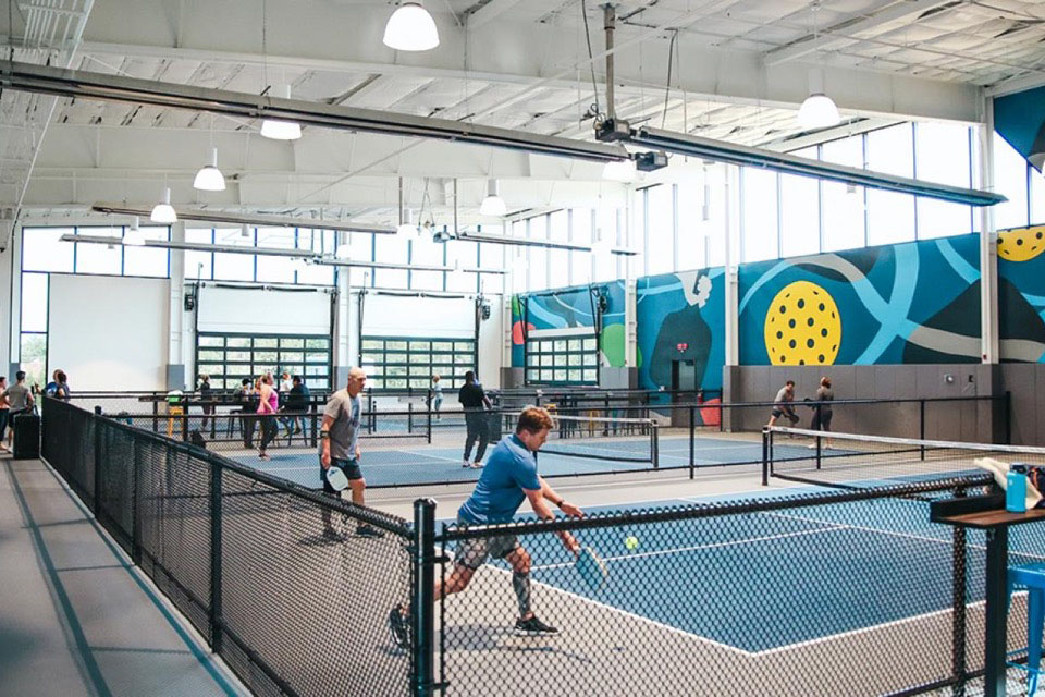 Several people playing on a pickleball court