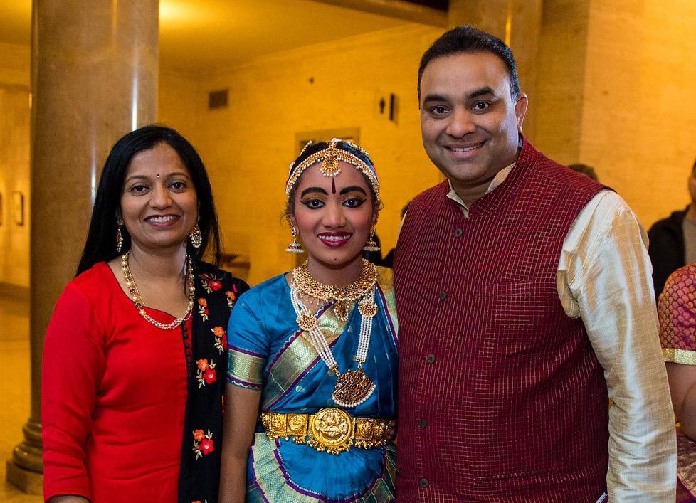 Young girl with mother and father, all dressed in traditional Indian attire