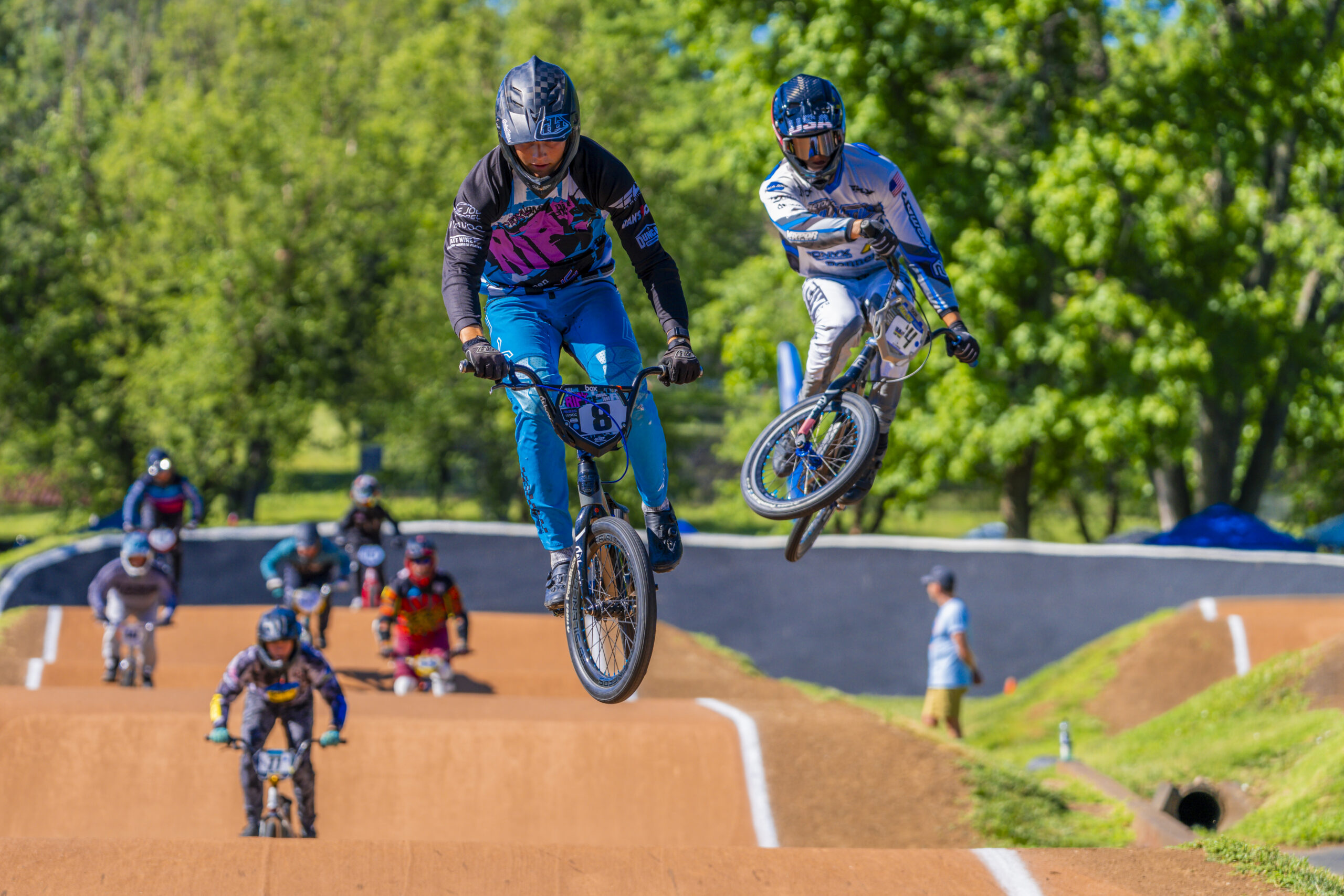 BMX riders going through the air off a hill