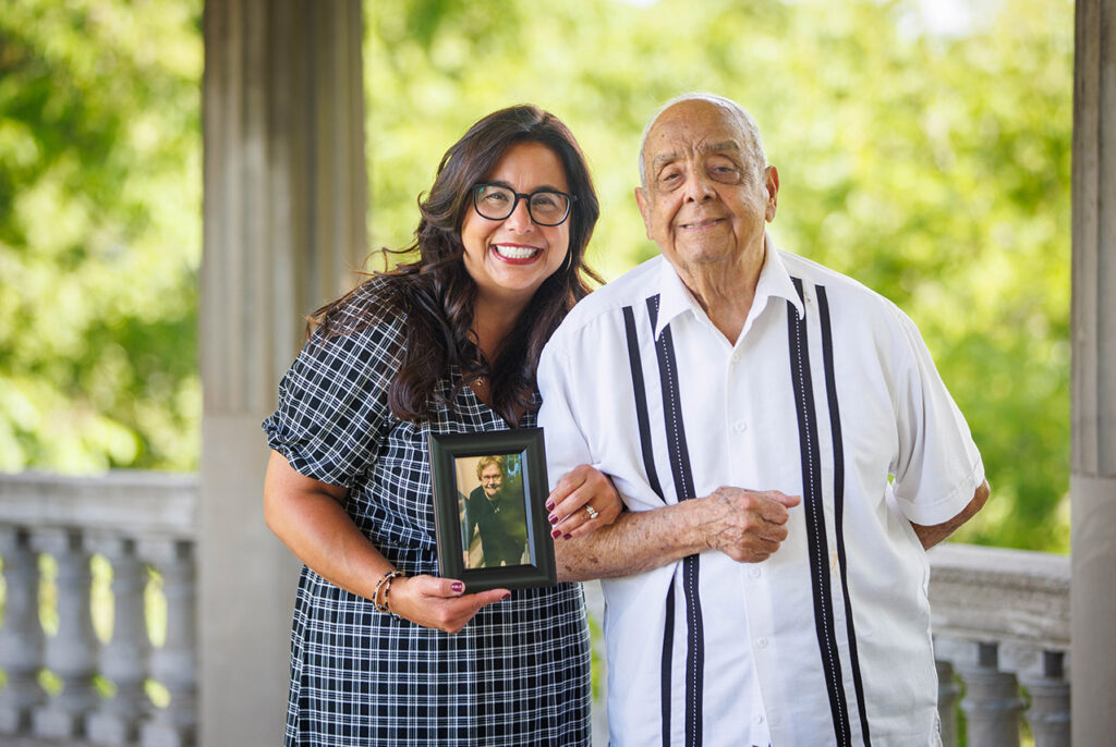 Noeida and her father, holding a picture of her late mother. 