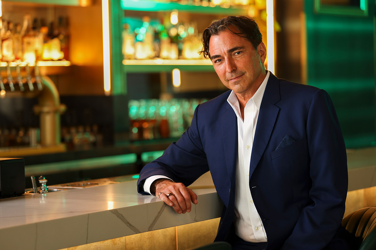 David Manica leaning on the bar at his cocktail bar, Verdigris.