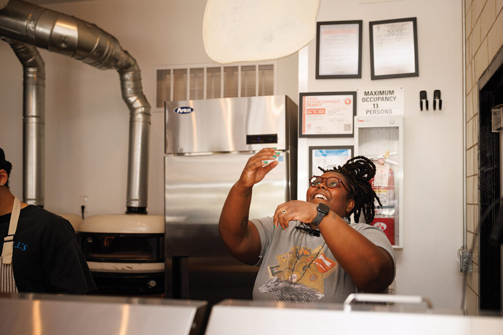 Jhy Coulter throwing pizza dough in the air.