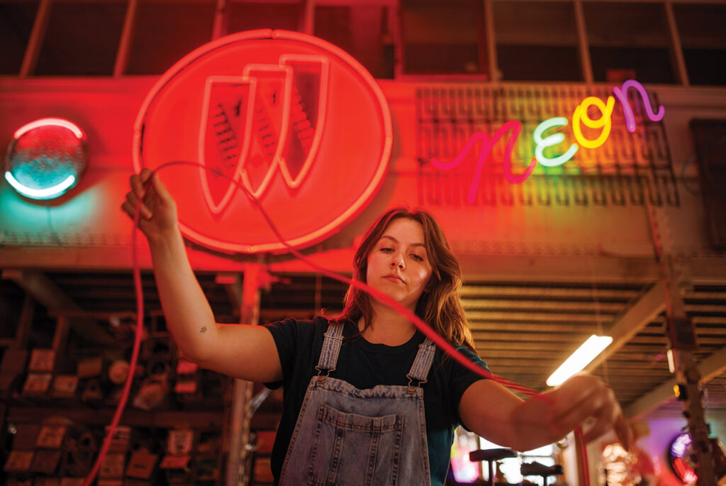 Olivia working on a neon sign.