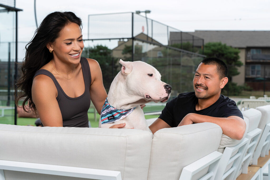 Lo'eau on a couch with her husband and dog. 