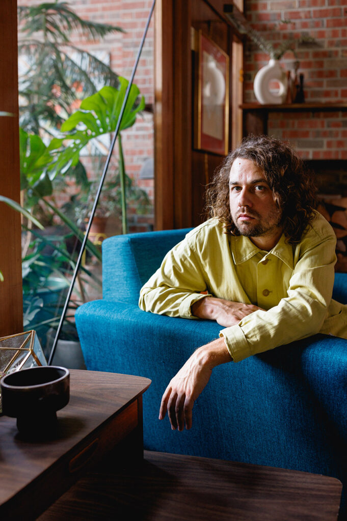 Kevin Morby sitting in a blue chair. 