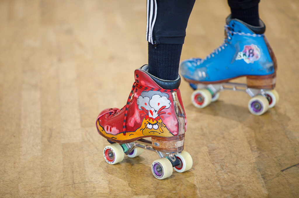 A close up of custom roller skates with volcanic art.
