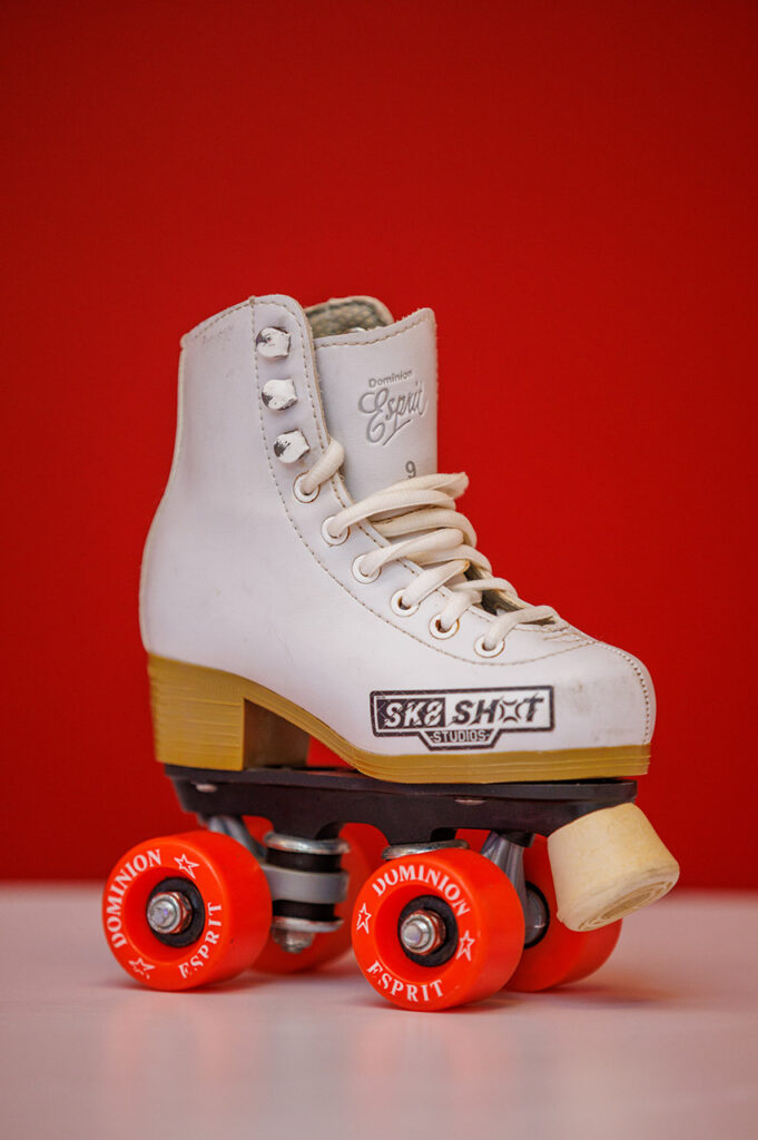 A white roller skate with the Skate Shot logo.