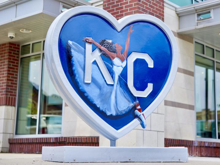 A heart sculpture with the letters KC and a ballerina painted on