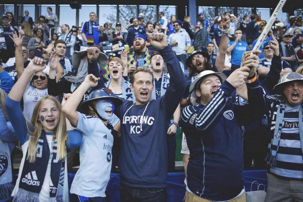 Crowd of cheering Sporting KC fans wearing team apparel