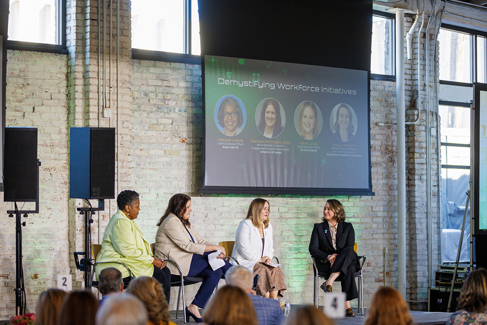 Four panelists seated on a stage