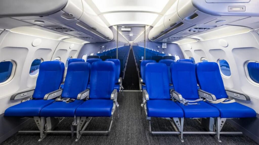 Mockup of a plane interior, including 12 real blue airplane seats and a simulated background for the back of the plane